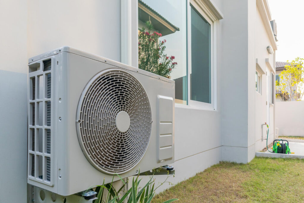 White air conditioner unit installed outside a house.